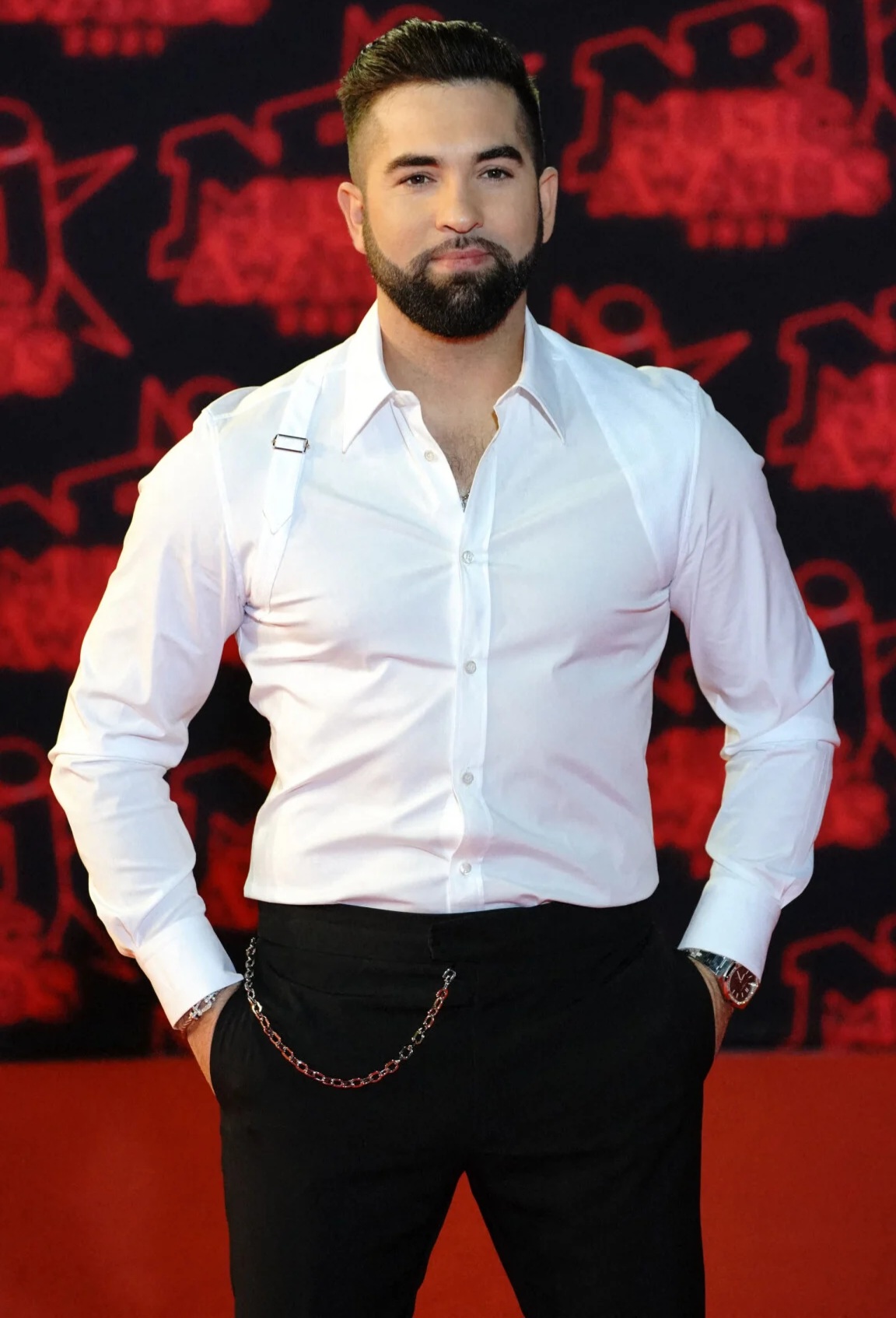 In which pose does the handsome singer look more powerful and predatory than his black bodyguard?